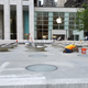 Workers cementing metallic objects onto the ground outside the new Apple Store